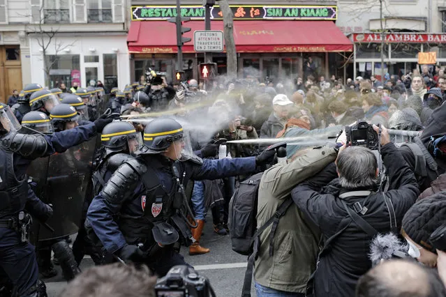 Policemen fight with activists during a protest ahead of the 2015 Paris Climate Conference at the place de la Republique, in Paris, Sunday, November 29, 2015. (Photo by Laurent Cipriani/AP Photo)