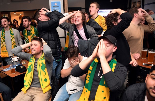 Australian fans react in a pub in Melbourne early June 27, 2018, as they watch Australia play Peru in their Russia 2018 World Cup Group C football match on a giant screen. (Photo by William West/AFP Photo)
