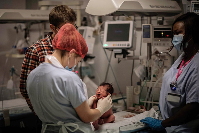 Nurses look after a newborn, during the Covid-19 pandemic, novel coronavirus at the maternity of the Diaconesses hospital in Paris, on November 17, 2020. (Photo by Martin Bureau/AFP Photo)