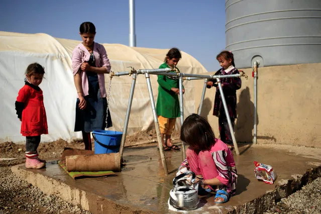 Newly displaced girls stand at the water point in Khazer refugee camp, Iraq November 11, 2016. (Photo by Zohra Bensemra/Reuters)