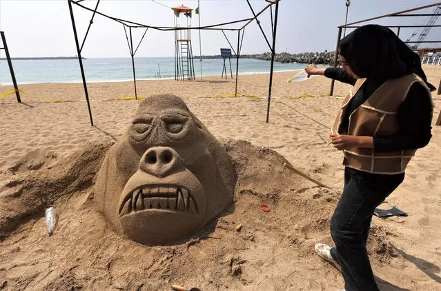 Omnia Raafat, a Fine Arts student at Matrouh University, sprays water to keep the sand cohesive, on her project “King Kong (Gorilla)”, during the competition for the best sand sculptures, in the “Alexandria Sand Sculpture Festival”, to promote tourism and mark the beginning of summer, at Al Saraya public beach, in Alexandria, Egypt on May 9, 2023. (Photo by Amr Abdallah Dalsh/Reuters)