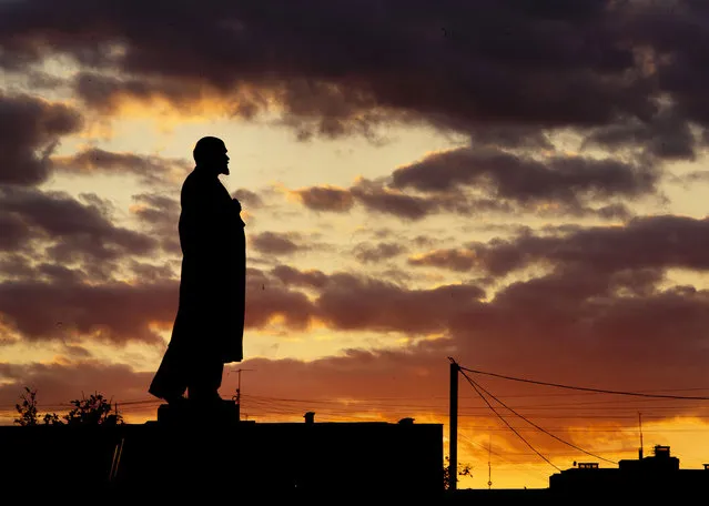 In this Thursday, June 21, 2018 filer, a Lenin statue stands on a column as the sun sets during the 2018 soccer World Cup in Podolsk near Moscow, Russia. (Photo by Michael Probst/AP Photo)