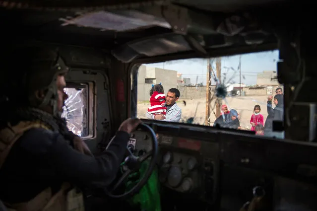 People fleeing the fighting are seen from inside an Iraqi Special Forces 2nd division Humvee in Mosul's Arbagiah neighbourhood on November 13, 2016, as they continued to battle Islamic State (IS) group forces pushing through the Arbagiah area and into the neighbourhood of Karkukli. (Photo by Odd Andersen/AFP Photo)