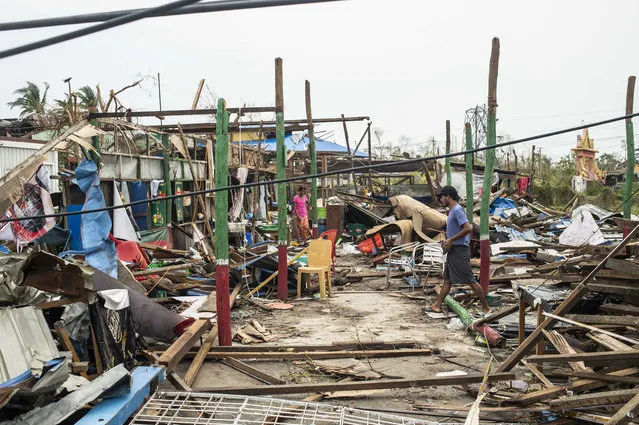 Local residents walk past damaged buildings after Cyclone Mocha in Sittwe township, Rakhine State, Myanmar, Tuesday, May 16, 2023. Myanmar’s military information office said the storm had damaged houses and electrical transformers in Sittwe, Kyaukpyu, and Gwa townships. (Photo by AP Photo/Stringer)