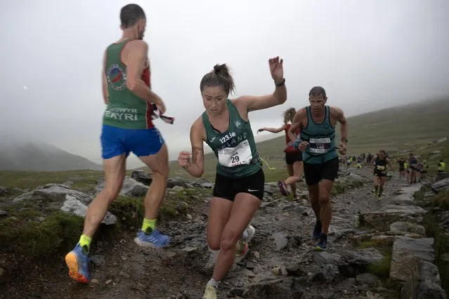 Ireland's Lisa Hegarty (C) competes in the 46th International Snowdon Race, a race to the summit of the highest mountain in Wales, and back, near to the village of Llanberis in north Wales on July 15, 2023, this year shortened due to the terrible weather. The main International Snowdon Race, now in it's 48th year, is considered as one of the greatest in the world of mountain running, and attracts some of the best racers in Europe. (Photo by Oli Scarff/AFP Photo)