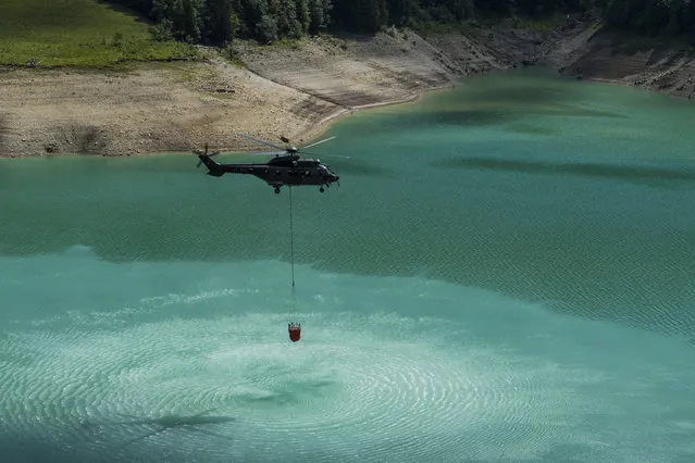 A Swiss Army Super Puma helicopter transports water from the lake of the Hongrin dam to the Culand meadow above Rossiniere to water a farmer's cows during a fishing trip. A press briefing on the water supply system for the alpine pastures affected by drought in the Vaud canton on Tuesday, 7 August 2018 at the lake of the Hongrin dam near La Lecherette. (Photo by Jean-Christophe Bott/KEYSTONE)