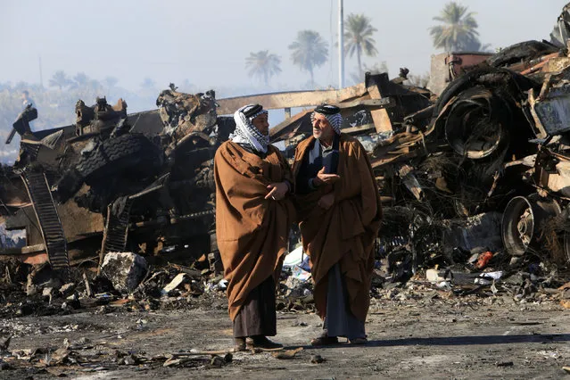 People gather at the site of a suicide truck bomb attack, at a petrol station in the city of Hilla, south of Baghdad, Iraq, November 25, 2016. (Photo by Alaa Al-Marjani/Reuters)