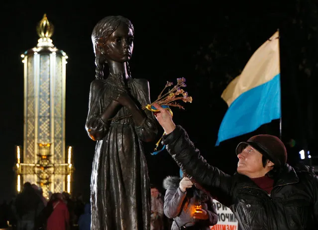 A woman places flowers at a monument to Holodomor victims during a commemoration ceremony marking the 83rd anniversary of the famine of 1932-33 in which millions died of hunger, in Kiev, Ukraine, November 26, 2016. (Photo by Valentyn Ogirenko/Reuters)