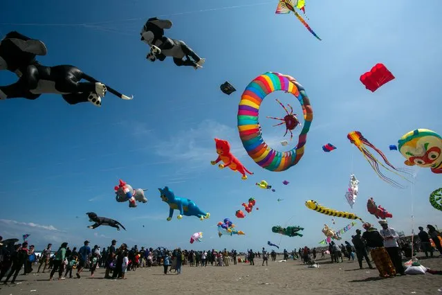 Participants play with kites during the International kites festival in Bantul, Yogyakarta on July 16, 2023. (Photo by Devi Rahman/AFP Photo)