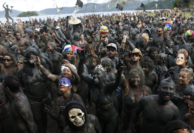 People covered in mud attend the traditional “Bloco da Lama” or “Mud Block” carnival party, in Paraty, Brazil, Saturday, February 14, 2015. (Photo by Leo Correa/AP Photo)