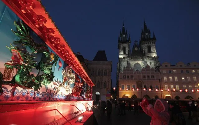 A woman takes a picture of an installation during Chinese Lunar New Year celebrations at the Old Town Square in Prague February 19, 2015. (Photo by David W. Cerny/Reuters)