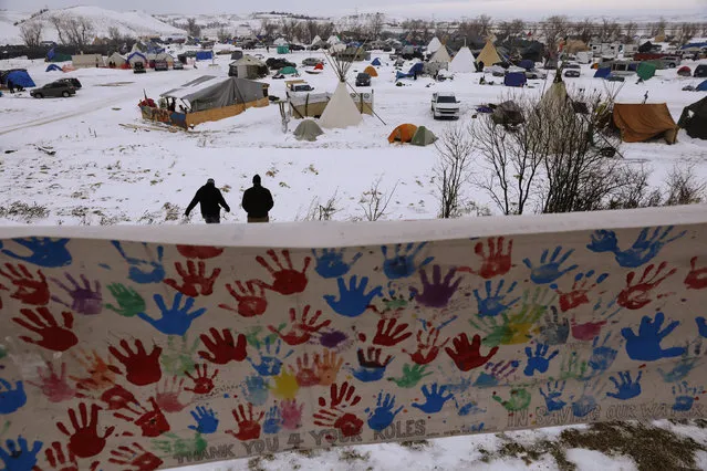 Two campers walk through the Oceti Sakowin camp as “water protectors” continue to demonstrate against plans to pass the Dakota Access pipeline near the Standing Rock Indian Reservation, near Cannon Ball, North Dakota, U.S., December 2, 2016. (Photo by Lucas Jackson/Reuters)