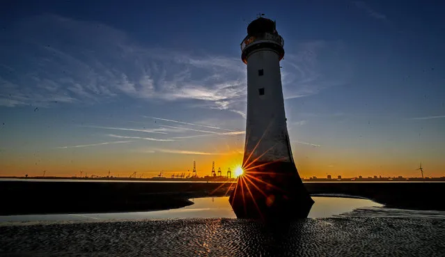 The sun rises behind the lighthouse at New Brighton beach on the Wirral, Merseyside. UK on June 25, 2018. (Photo by Peter Byrne/PA Images via Getty Images)