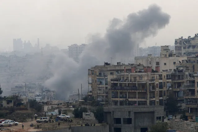 Smoke rises near Pro-Syrian government soldiers after shelling, in al-Izaa area in Aleppo, Syria December 5, 2016. (Photo by Omar Sanadiki/Reuters)