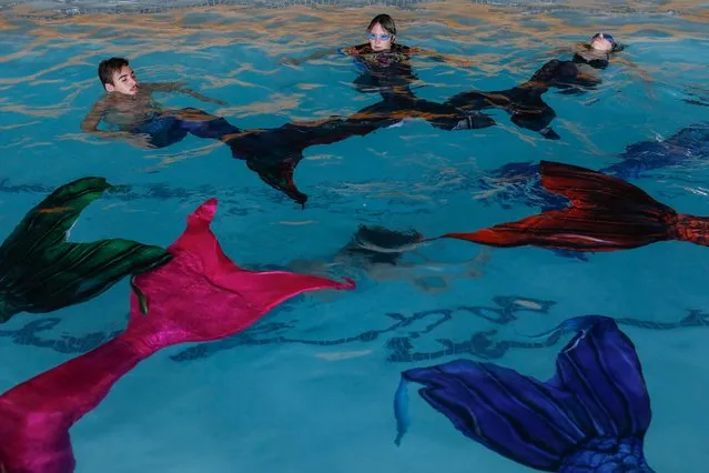 Students perform a routine during their mermaiding class at the Merschool in Kayalami, near Midrand, on June 3, 2022.  Mermaiding is a fast growing sport world wide and includes several skills such as monofin swimming, sculling, tricks and breath hold. (Photo by Phill Magakoe/AFP Photo)