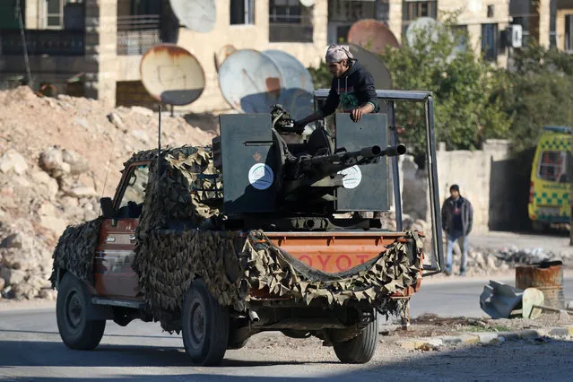 A rebel fighter stands on a pick-up truck mounted with a weapon in a rebel-held area of Aleppo, Syria December 9, 2016. (Photo by Abdalrhman Ismail/Reuters)