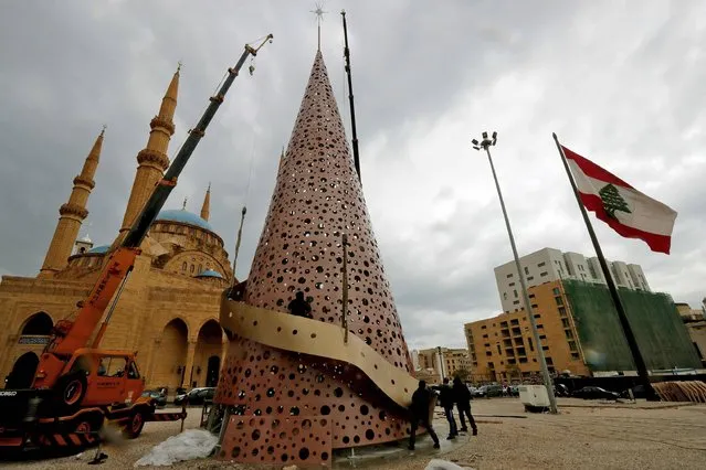 Workers set up Christmas decorations in Beirut's Martyr Square on December 16, 2016. (Photo by Joseph Eid/AFP Photo)