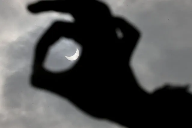 People observe the solar eclipse in Milan on March 20, 2015. (Photo by Fotogramma/Splash News)