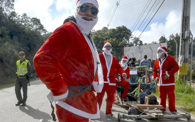 Participants fancy dressed as Santa Claus attend the XXVII Car Festival before going downhill in a homemade cart in the Santa Elena Municipality, near Medellin, Antioquia department, Colombia, on December 18, 2016. (Photo by Raul Arboleda/AFP Photo)