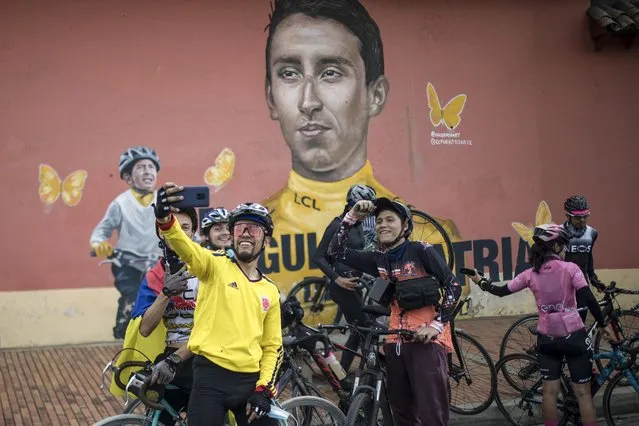 Cyclers gather around a mural of Colombian cyclist Egan Bernal in his hometown of Zipaquira, Colombia, Sunday, May 30, 2021. Bernal won the Giro d'Italy cycling race in Milan. (Photo by Ivan Valencia/AP Photo)