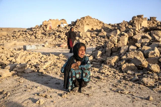 An Afghan girl cries in front of her house that was destroyed by the earthquake in Zenda Jan district in Herat province, western Afghanistan, Wednesday, Octoner 11, 2023. Another strong earthquake shook western Afghanistan on Wednesday morning after an earlier one killed more than 2,000 people and flattened whole villages in Herat province in what was one of the most destructive quakes in the country's recent history. (Photo by Ebrahim Noroozi/AP Photo)