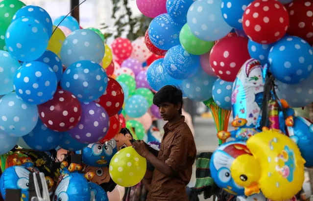 An Indian boy sells balloon on the roadside ahead of Universal Children’s Day, in Mira road on the outskirts of Mumbai, India, 19 November 2018. Universal Children's Day is observed every year on 20 November to promote awareness among children worldwide and improving children’s welfare. (Photo by Divyakant Solanki/EPA/EFE)