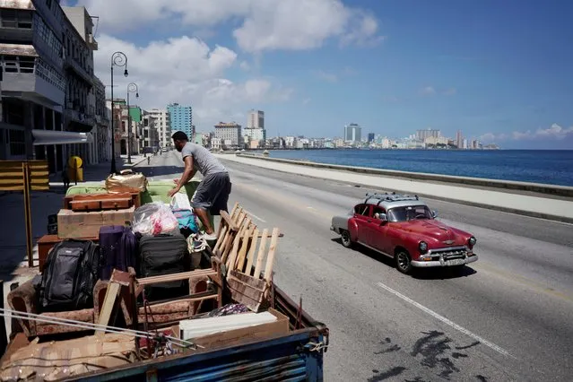 A man loads a truck with furniture to be relocated prior to the arrival of Storm Elsa, in Havana, Cuba, July 4, 2021. (Photo by Alexandre Meneghini/Reuters)