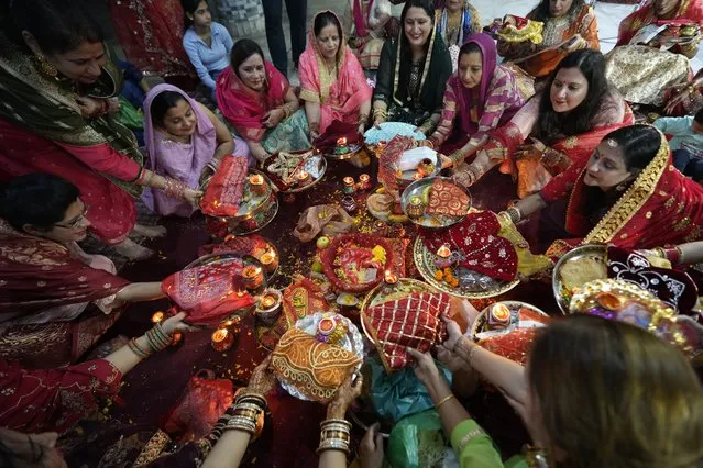 Married Hindu women perform rituals during Karva Chauth festival in Jammu, India, Thursday, November 1, 2023. Married Hindu women observe a day long fast to pray for the longevity and well being of their husbands during this festival. (Photo by Channi Anand/AP Photo)