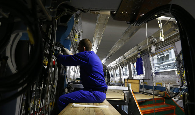 An employee works on an electric train assembly line at the “Stadler Minsk” plant in Fanipol, Belarus February 10, 2016. (Photo by Vasily Fedosenko/Reuters)