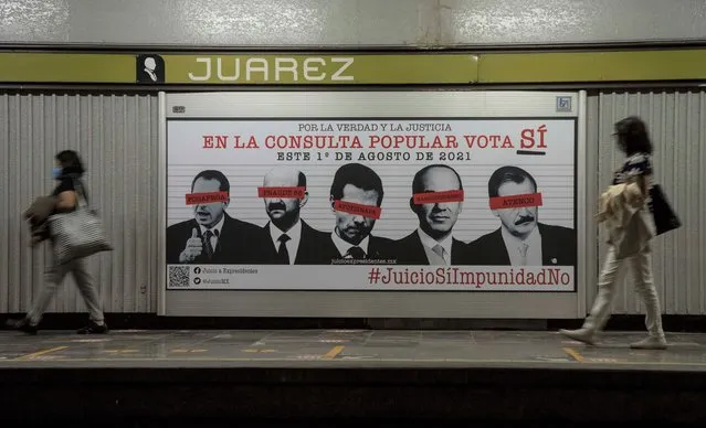 Commuters walk past an advertisement showing images of several Mexican former presidents, obscuring their eyes with red bars, and calling for citizens to participate in a referendum on whether ex-presidents should be tried for their alleged crimes during their time in office, in Mexico City, Saturday, July 31, 2021. The yes-or-no referendum on Sunday is going to cost Mexico about $25 million, and the vote is being held in the middle of a third wave of the coronavirus pandemic. (Photo by Christian Palma/AP Photo)