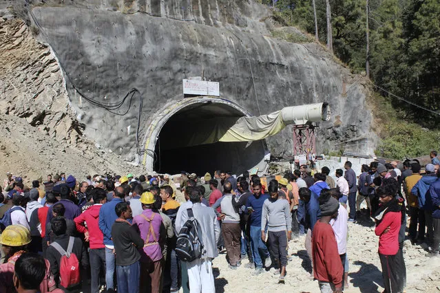People watch rescue and relief operations at the site of an under-construction road tunnel that collapsed in mountainous Uttarakhand state, India, Wednesday, November 15, 2023. Rescuers have been trying to drill wide pipes through excavated rubble to create a passage to free 40 construction workers trapped since Sunday. A landslide Sunday caused a portion of the 4.5-kilometer (2.7-mile) tunnel to collapse about 200 meters (500 feet) from the entrance. It is a hilly tract of land, prone to landslide and subsidence. (Photo by AP Photo)