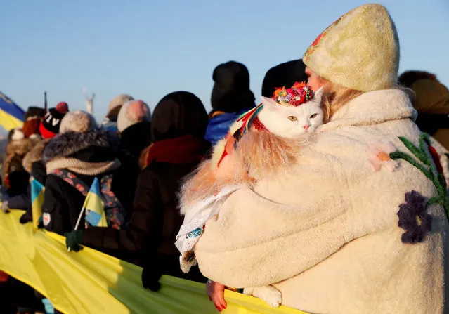 A woman holds a cat during a gathering on a bridge across the Dnipro River as people celebrate the Day of Unity in Kiev, Ukraine January 22, 2019. (Photo by Valentyn Ogirenko/Reuters)