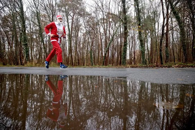 A person dressed as Santa Claus runs through the streets during the annual Nikolaus Lauf (Saint Nicholas run), in Michendorf, Germany on December 10, 2023. (Photo by Lisi Niesner/Reuters)