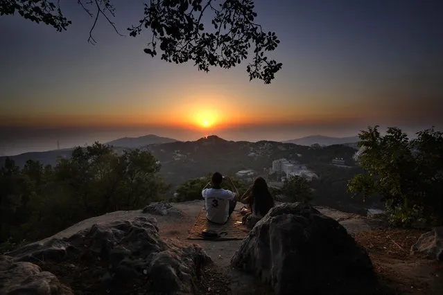A young couple enjoy the sunset during a hike trip in Chahtoul village, in the Keserwan district, Mount Lebanon Governorate of Lebanon, Sunday, June 27, 2021. (Photo by Hassan Ammar/AP Photo)
