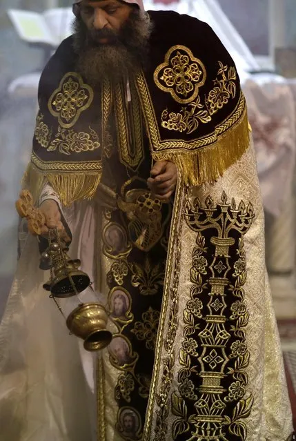 An Egyptian Coptic clergyman prays during the Easter Eve service at St. Sama'ans Church in the Mokattam district of Cairo, Egypt, Saturday, April 11, 2015. (Photo by Hassan Ammar/AP Photo)
