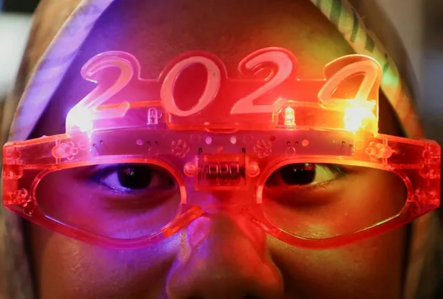A woman wears 2024 glasses during New Year's countdown at Kuala Lumpur, Malaysia on December 31, 2023. (Photo by Hasnoor Hussain/Reuters)