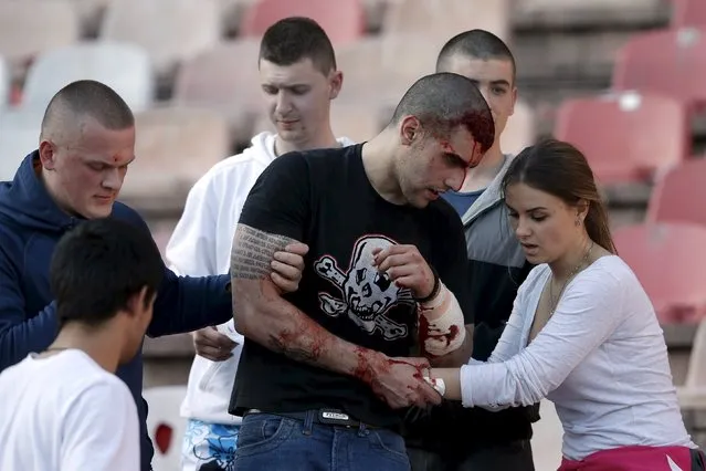 An injured Red Star Belgrade fan is helped by friends during clashes with riot police in the stadium before their Serbian Superliga soccer match against Partizan Belgrade in Belgrade, April 25, 2015. (Photo by Marko Djurica/Reuters)