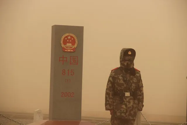 A paramilitary policeman stands guard at China's border with Mongolia, in a sand storm in Xilin Gol League, Inner Mongolia, China, March 4, 2016. (Photo by Reuters/Stringer)
