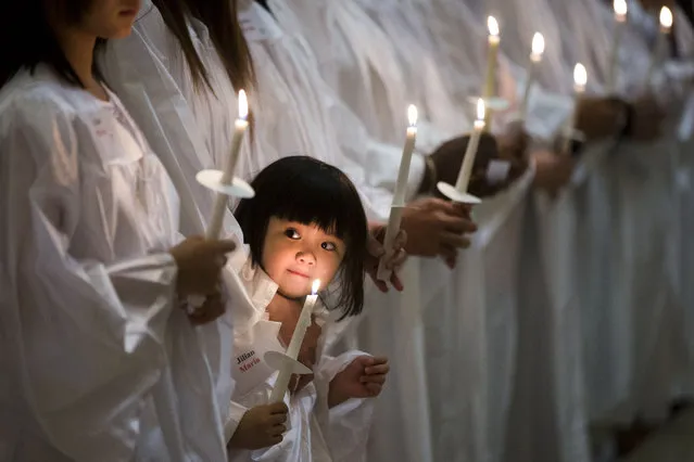 In this Saturday, April 4, 2015 photo, Vietnamese-American Jillian Nguyen, 3, stands with others during their baptism into the Catholic faith, at Saint Helena Catholic Church in Philadelphia. (Photo by Matt Rourke/AP Photo)