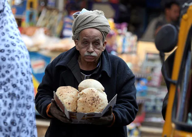 Egyptian man holds bread at the vegetables market in Cairo, Egypt January 10, 2017. (Photo by Mohamed Abd El Ghany/Reuters)