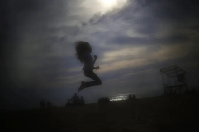 This Sunday, May 3, 2015 photo, shows a girl jumping at the public beach of Ramlet al Bayda in Beirut, Lebanon. (Photo by Hassan Ammar/AP Photo)