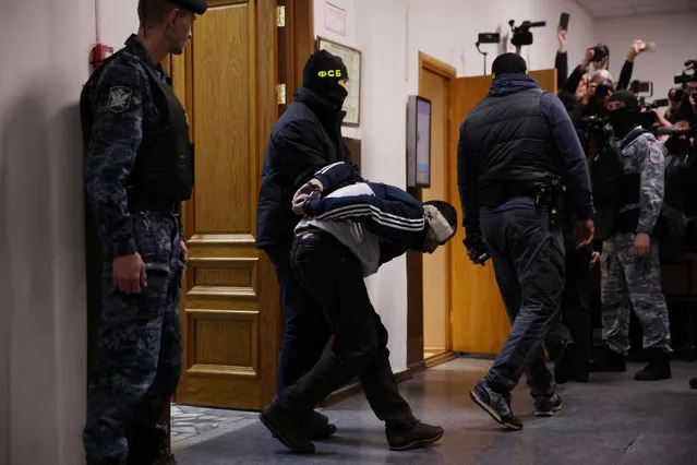A man suspected of taking part in the attack of a concert hall that killed 137 people, the deadliest attack in Europe to have been claimed by the Islamic State jihadist group, is escorted by Russian law enforcement officers prior to his pre-trial detention hearing at the Basmanny District Court in Moscow on March 24, 2024. At least 137 people, including three children, were killed when camouflaged gunmen stormed the Crocus City Hall, in Moscow's northern suburb of Krasnogorsk, and then set fire to the building on March 22 evening. (Photo by Tatyana Makeyeva/AFP Photo)
