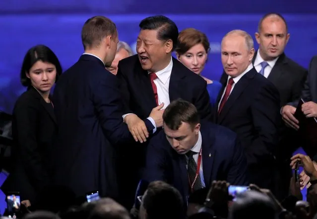 Bodyguards support Chinese President Xi Jinping, center, as he leaves a podium at the St. Petersburg International Economic Forum in St. Petersburg, Russia, Friday, June 7, 2019. (Photo by Maxim Shemetov/Reuters)