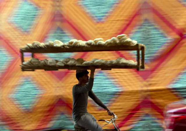 A vendor carries bread tray over his bicycle, in Cairo, Egypt, Friday, March 3, 2017. (Photo by Amr Nabil/AP Photo)