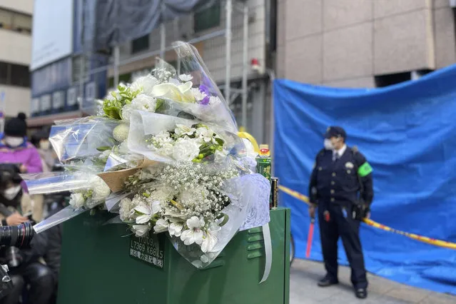 Flowers and drinks are placed in front of a building where a fire broke out Friday in Osaka, western Japan, Saturday, December 18, 2021. Japanese police on Saturday searched the house of one of the patients at a mental clinic where the fire gutted an entire floor in the eight-story building, killing over 20 people trapped inside.  (Photo by Chisato Tanaka/AP Photo)
