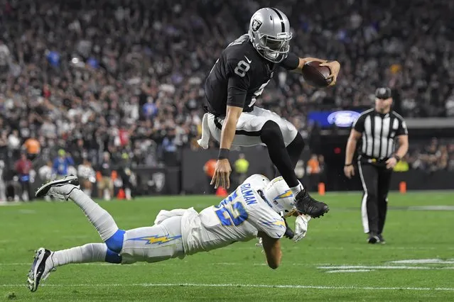 Las Vegas Raiders' Marcus Mariota (8) runs for a gain against Los Angeles Chargers safety Alohi Gilman (32) during the second half of an NFL football game, Sunday, January 9, 2022, in Las Vegas. (Photo by David Becker/AP Photo)