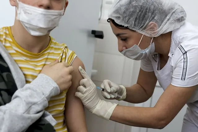 A teenager receives a dose of Russia's Sputnik M (Gam-COVID-Vac-M) COVID-19 vaccine in Krasnodar, Russia, Friday, January 28, 2022. This week, Russia started vaccinating children aged 12-17 with a domestically developed shot, Spuntik M – a version of the Sputnik V vaccine that contains a smaller dose – amid reports of a sharp spike of COVID-19 infections and hospitalization in children. (Photo by Vitaliy Timkiv/AP Photo)