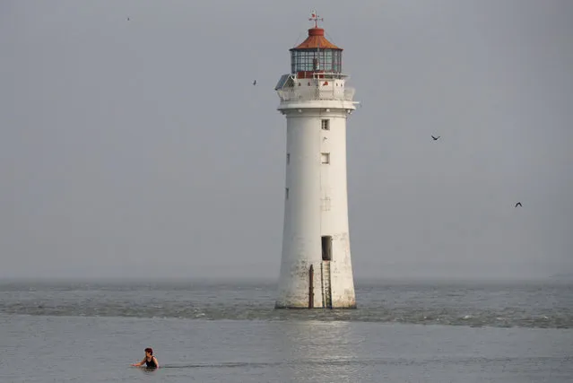 A woman swims in the sea in front of Perch Rock Lighthouse in New Brighton, Britain, April 18, 2019. (Photo by Phil Noble/Reuters)