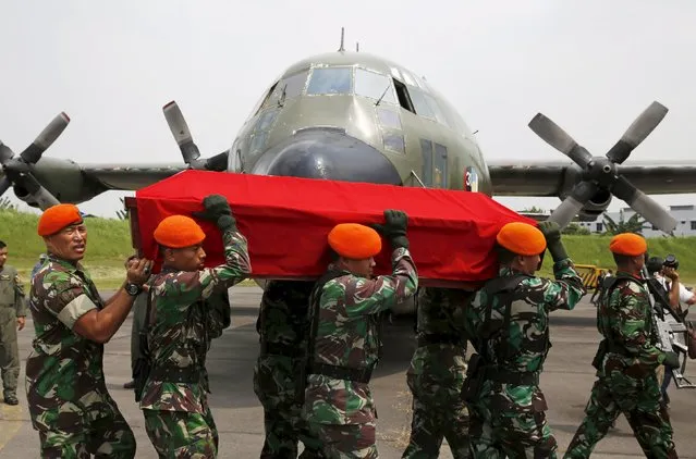 Indonesian air force soldiers carry the coffin of a victim of an Indonesian military C-130B Hercules aircraft that crashed into a residential area, near a Hercules C130 airplane at a military airbase in Medan, North Sumatra, Indonesia province July 1, 2015. (Photo by Reuters/Beawiharta)