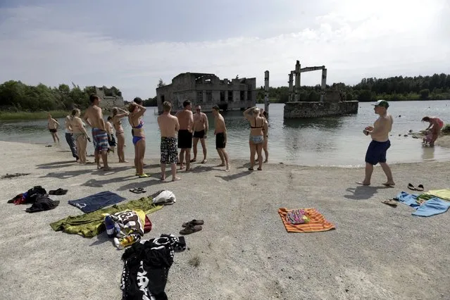 People get ready to swim near Murru prison, an abandoned Soviet prison, in Rummu quarry, Estonia, during hot weather July 4, 2015. (Photo by Ints Kalnins/Reuters)